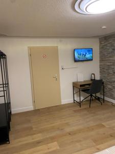an empty room with a desk and a tv on the wall at Ferienhaus "LE RUISSEAU" Ihr großzügiges Ferienhaus in Badenweiler in Badenweiler