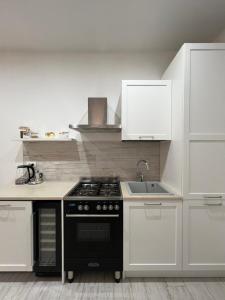 a kitchen with a black stove and a sink at Casa nel vicolo in Montichiari