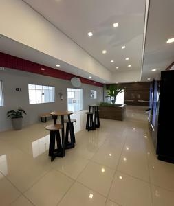 a lobby with a table and stools in a building at Diamante de Sorocaba! Piscina incrível! in Sorocaba +38 photos