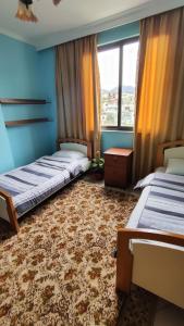 une chambre avec deux lits et une grande fenêtre dans l'établissement Warm Wooden Escape, Cozy & Elegant Stay, à Tirana