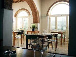 a dining room with tables and chairs and windows at Podere Riparbella in Massa Marittima