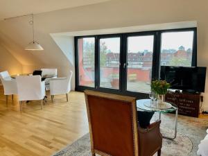a living room with a table and a dining room at Charmante Penthouse Wohnung in Krefeld