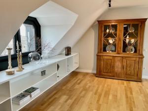 a room with a large wooden cabinet with vases on it at Charmante Penthouse Wohnung in Krefeld +20 photos