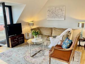 a living room with a couch and a table at Charmante Penthouse Wohnung in Krefeld