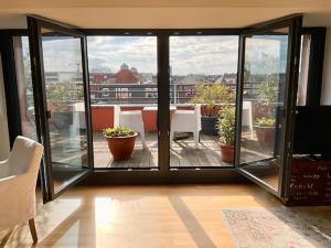 a room with a balcony with a table and chairs at Charmante Penthouse Wohnung in Krefeld