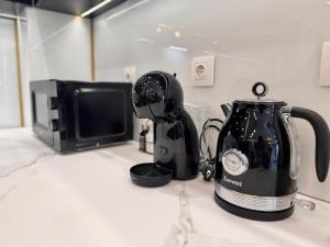 una licuadora sentada en un mostrador junto a un microondas en Luxury Apartment with Parking Just Steps from the Beach in the Heart of Burgas!, en Burgas