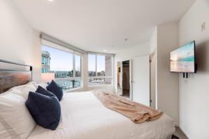 a bedroom with a large bed and a flat screen tv at Opal Escape - Penthouse Marina view Private Rooftop in Los Angeles