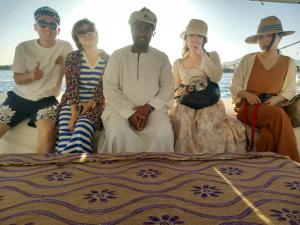 a group of people sitting on a boat at جزيرة العوامية in Luxor