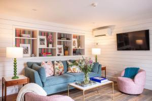 a living room with a blue couch and two chairs at Solarium at Cassa Zoe in Charleston