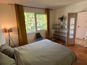 a bedroom with a bed and a desk and a window at BXX Private complex 10 min PARIS EXPO 12 rooms in Bagneux