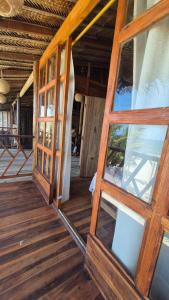 a room with wooden floors and windows in a house at Puerto Manglar Hostal in Guachaca