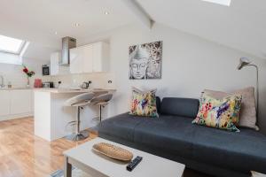 a living room with a couch and a kitchen at Central Knutsford Apartment in Knutsford