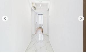 a hallway with white walls and white marble floors at Unique apartments in Timişoara +1 photo