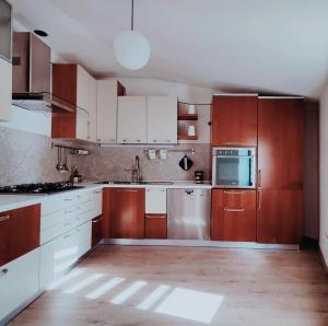 a kitchen with wooden cabinets and a stainless steel refrigerator at La Collina in Monteforte dʼAlpone