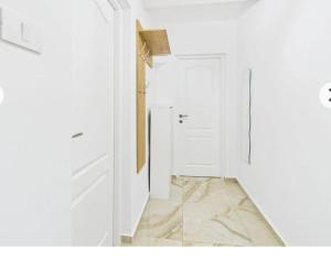a hallway with a white door and a tile floor at Unique apartments in Timişoara
