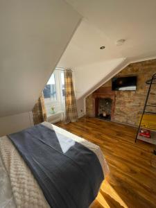 ラーグスにあるLargs Top Floor Flatの大きなベッドと暖炉のある寝室