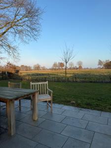 a wooden picnic table and bench sitting on a patio at Ferienhaus Hygge am Dümmersee in Hüde