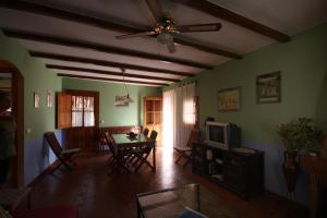 a living room with a table and a ceiling fan at Casa Rural Valle del Arrago in Robledillo de Gata