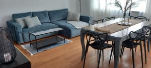 salon ze stołem i niebieską kanapą w obiekcie AnJa Apartment w mieście Sandomierz