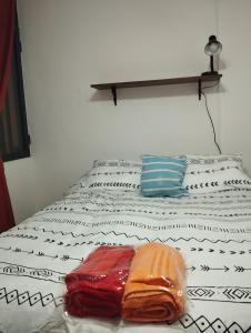 a bed with white and black sheets and pillows at Depto cómodo por Av Libertador in San Juan +32 photos