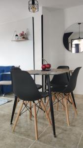 - une table à manger avec 2 chaises noires et une table dans l'établissement Apto piso 2 amoblado en Bucaramanga, à Bucaramanga