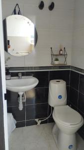une salle de bain avec toilettes, lavabo et miroir dans l'établissement Apto piso 2 amoblado en Bucaramanga, à Bucaramanga