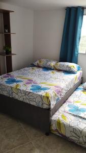 une chambre avec un lit avec un couvre-lit fleuri dans l'établissement Apto piso 2 amoblado en Bucaramanga, à Bucaramanga
