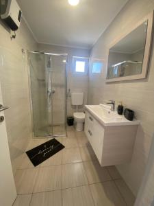 łazienka z prysznicem, umywalką i toaletą w obiekcie Dorothy Apartman Vir w mieście Vir +19 zdjęć