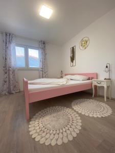 sypialnia z różowym łóżkiem i dywanem w obiekcie Dorothy Apartman Vir w mieście Vir