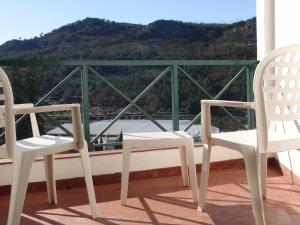 two white chairs sitting on a balcony with a view at Hotel Castelo de Vide in Castelo de Vide