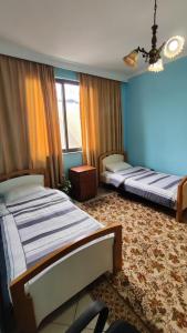 deux lits dans une chambre aux murs bleus dans l'établissement Warm Wooden Escape, Cozy & Elegant Stay, à Tirana