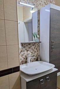 a bathroom with a white sink and a mirror at Morina Apartment Prishtina in Pristina