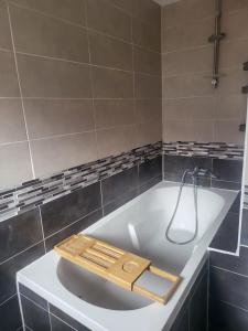 a bath tub with a wooden tray on top of it at L'Escale 3 Chambres Clermont-Ferrand in Clermont-Ferrand +21 photos