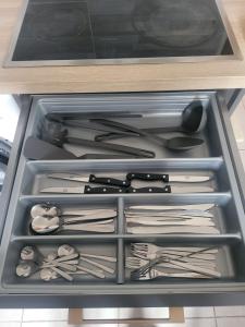 a drawer full of utensils in a refrigerator at L'Escale Atypique 3 Chambres Clermont-Ferrand, Parking, Jardin in Clermont-Ferrand