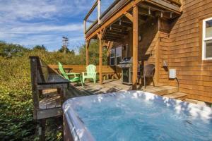 einen Whirlpool auf einer Terrasse neben einem Haus in der Unterkunft 3br Hot Tub Ocean Views & King Beds Near Beach in Nehalem