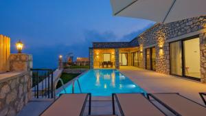 a villa with a swimming pool at night at Villa TEPE in Arsaköy