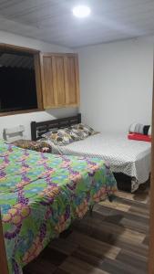 two beds sitting in a room with at Paisaje Andino Salento in Salento +10 photos