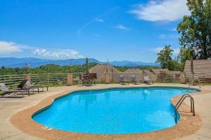 a swimming pool with blue water in a yard at Skinny Bear Lodge in Sevierville