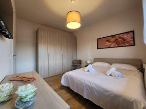 una camera da letto con un letto bianco e un tavolo di Attico Fibonacci - Affitti Brevi Italia a Pisa