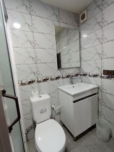 a white bathroom with a toilet and a sink at résidence sara in Fez