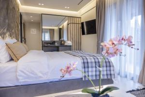 a bedroom with a white bed and a large mirror at Polyzos Luxury Suites Meteora #3 - Adults Friendly in Kalabaka