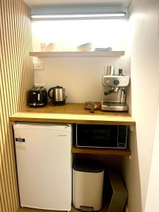 a small kitchen with a counter and a microwave at The Dream Whale Bay in Raglan