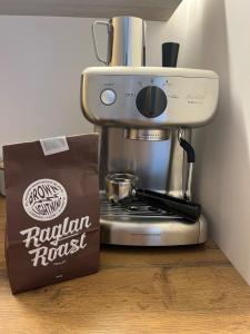 a coffee maker and a bag on a counter at The Dream Whale Bay in Raglan
