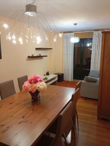 a dining room table with a vase of flowers on it at Piso ABELEDO in Sarria