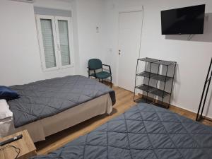 a bedroom with a bed and a chair and a television at casa dia in Valdeganga