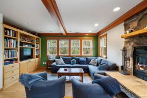 ein Wohnzimmer mit einer blauen Couch und einem Kamin in der Unterkunft 3br Hot Tub Ocean Views & King Beds Near Beach in Nehalem