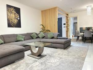 a living room with a couch and a glass table at AndBert Lodge Gh in New Weija