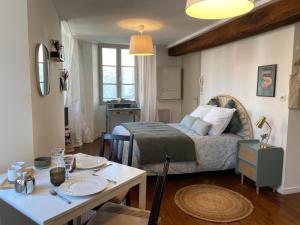 a bedroom with a bed and a table with a table sidx sidx sidx at La Bohème ô coeur du centre ville in Les Herbiers +11 photos