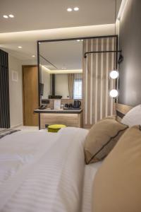 a bedroom with a large white bed with a mirror at Polyzos Luxury Suites Meteora #5 - Adults Friendly in Kalabaka