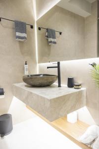 a bathroom with a bowl sink on a counter at Polyzos Luxury Suites Meteora #5 - Adults Friendly in Kalabaka